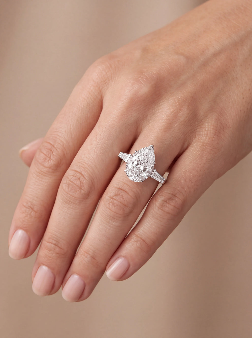 Anel de noivado diamante pera 4ct trilogia baguete em ouro branco visto na mão — 1999